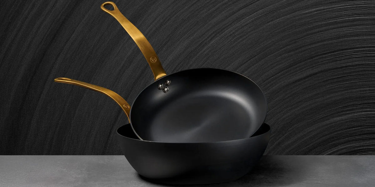 Padelle in ferro nero FB Kitchenware con manici dorati, ideali per cotture professionali ad alta temperatura — immagine generata con AI